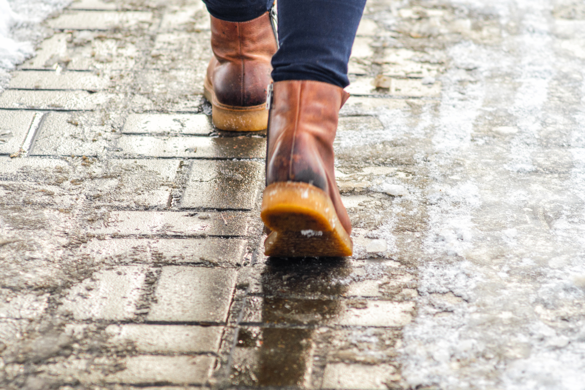 close up of worker in boots walking on icy path