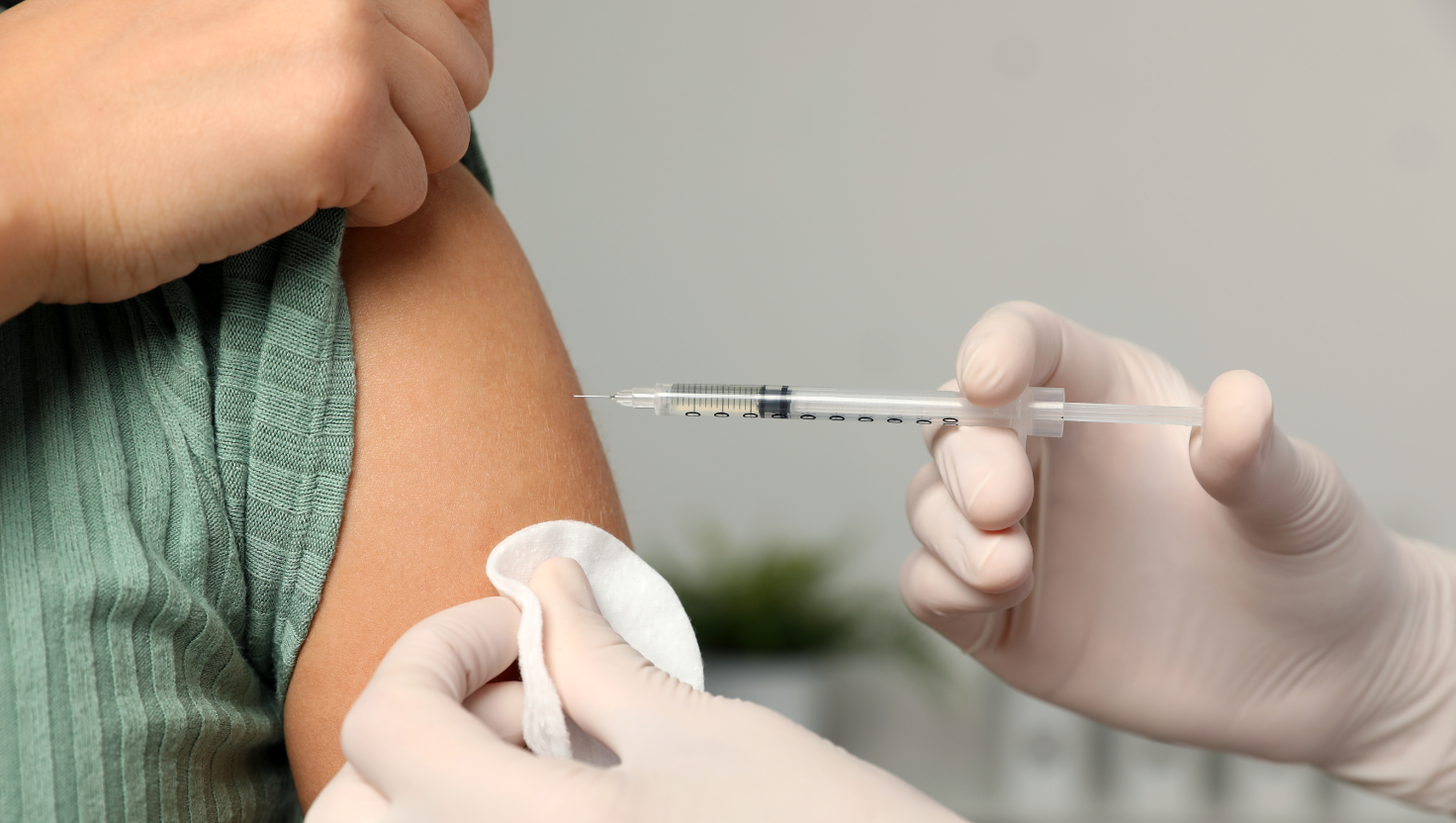 Close shot of physician giving patient a shot in the arm